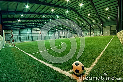 Soccer ball on green grass in an indoor playground Stock Photo