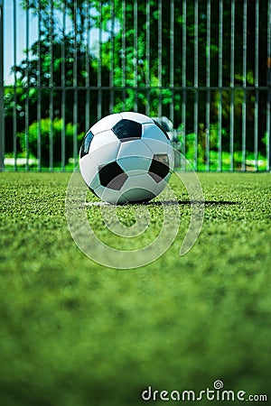 Soccer ball on penalty spot in cage football ground, street soccer in summer Stock Photo