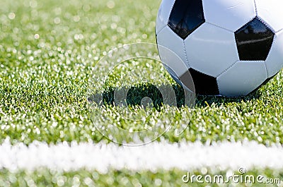 Soccer ball sitting in grass close to line Stock Photo