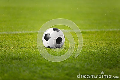 The Soccer Ball On Stadium Green Field. Football Pitch in the Background Stock Photo