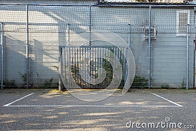 Soccer cage in the city, iron gate protection grid with soccer court behind it, empty Stock Photo