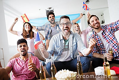 Soccer fans emotionally watching game in the living room. Stock Photo