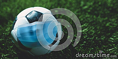 Soccer, football ball in medical mask. Sport against coronavirus COVID-19 Stock Photo