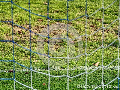 Soccer or football corner lines through safety net. View from behind the tribune net with blurred stadium and field pitch Stock Photo