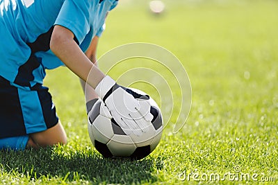 Soccer Goalie With Classic Football Ball. Goalkeeper on Grass Field Holding Ball in Hands Stock Photo