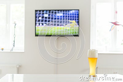 Soccer penalty on television and a glass of wheat beer on a table Stock Photo