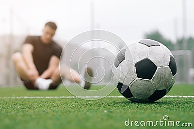 Soccer player A man holds his foot. focus on the soccer ball. Dislocation or sprain of the joint Stock Photo