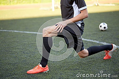 Soccer player stretching leg on field football Stock Photo