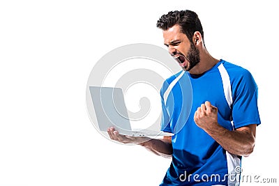 Soccer player using laptop and cheering Stock Photo