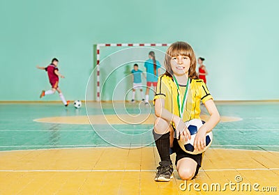 Soccer team captain standing on knee in futsal Stock Photo