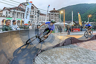 Sochi, Russia - July 11, 2015: Sportsmen bikers on outdoor pump track at Gorky Gorod mountain resort. Bike riders run pursuit race Editorial Stock Photo