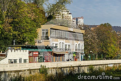 Beautiful autumn view of Sochi river. River embankment with buildings and trees. Sochi city center Editorial Stock Photo
