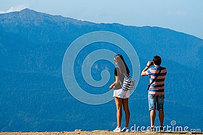 Sochi, Russia, 17 September 2020 - young man and woman standing on observation deck in mountains back to the camera, travel Editorial Stock Photo
