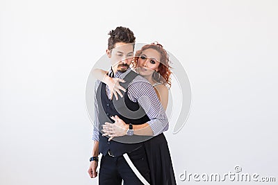 Social dance, bachata, kizomba, salsa, tango concept - Woman dressed in red dress and man in a black costume over white Stock Photo