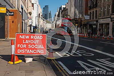 Social Distancing new road layout sign with London Double Decker Bus and St Paul`s Cathedral in the background during Covid 19 Editorial Stock Photo