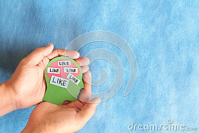 Social media addiction, mental health and belongingness concept. Hand holding a head profile with word like. Stock Photo