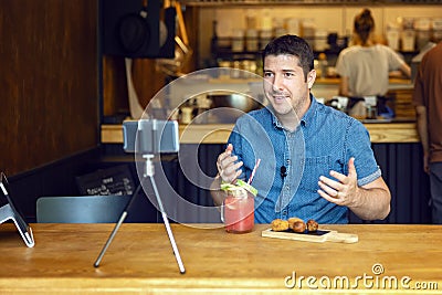 Social media influencer or food blogger filming video sharing online food review of new small restaurant business Stock Photo