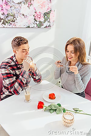 Social Media Marketing concept. Lovely young lady taking photo of a sweet dessert in cafe, making flatlay and looking Stock Photo