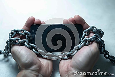Social media shackles Mobile phone symbolically chained to users hands Stock Photo