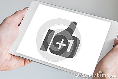 Social network symbol displayed on touchscreen of modern tablet held in two hands Stock Photo