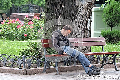 Odessa, Ukraine. A homeless sleep in a public park bench. Editorial Stock Photo