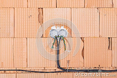 Socket back boxes with wires in a wall. Cabling background. Colorful electrical wires sticking out from electrical sockets hole. Stock Photo