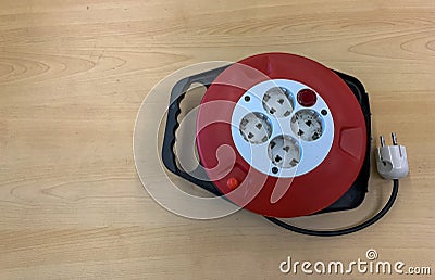 a socket with a red black and white combination that is on a wooden table. Stock Photo