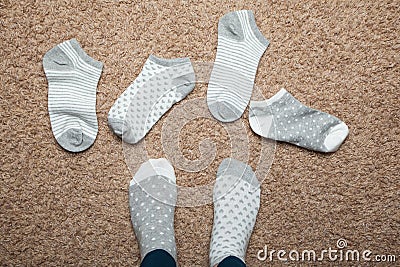 Socks with different patterns scattered on the floor in the house, choice Stock Photo