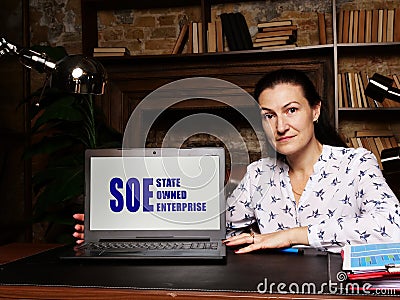 SOE STATE OWNED ENTERPRISE - Thoughtful female person showing laptop screen Stock Photo