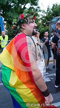 Sofia / Bulgaria - 10 June 2019: Fat guy with Rainbow Flag in the back and Crown of flowers supporting Sofia Pride walking in the Cartoon Illustration