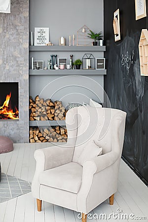 Soft armchair near blackboard wall and fireplace Stock Photo