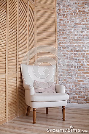 Soft armchair near brick wall. Stock Photo