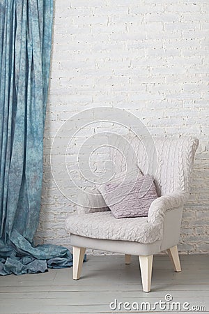 Soft armchair near brick wall. Stock Photo