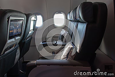 Soft armchairs in the right business class aircraft. Open porthole in a business class plane. Editorial Stock Photo