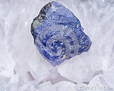 Soft blue violet rough TANZANITE from Tanzania placed on a crystalline druzy center of Polished Large Natural Blue Lace Agate Stock Photo