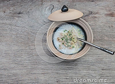 Soft-boiled rice in clay bowl with lid on a wooden tablle Stock Photo