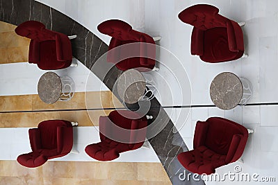 Soft burgundy armchairs and tables standing in hotel lobby top view Stock Photo