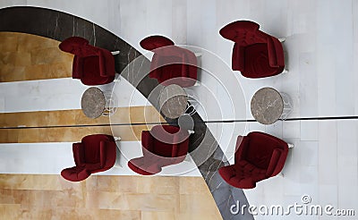 Soft burgundy armchairs and tables standing in hotel lobby top view Stock Photo