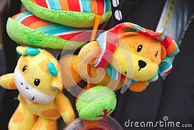 Soft cuddly toys hanging from a baby`s pushchair Stock Photo