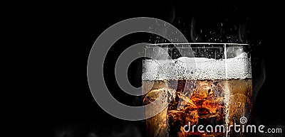 Soft drink glass with ice splash on cool smoke background. Cola glass with summer refreshment Stock Photo