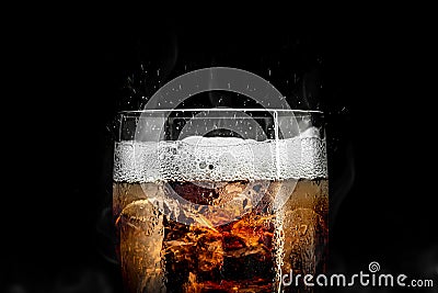 Soft drink glass with ice splash on cool smoke background. Cola glass with summer refreshment Stock Photo