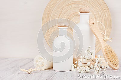 Soft elegant bathroom decor, template of white cosmetics bottles with comb, flowers on white wood board,copy space. Stock Photo