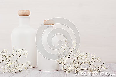 Soft elegant home decor with white bottles and small flowers on white wooden plank for advertising, designers, branding identity, Stock Photo