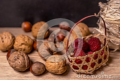 Soft focus, blurring background. Hazelnuts and walnuts. Raspberry wicker basket. Macro. Stock Photo