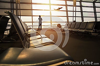 Soft Focus of Businessman in his Business Trip looking at Airplane Boarding in Airport Departures gate Terminal through Stock Photo