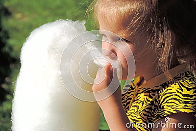 Soft focus of little girl eating cotton candy in the park for a walk Stock Photo