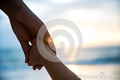 Soft focus parent hold the little child hand during sunset Stock Photo