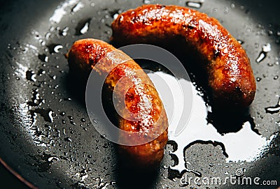 Soft focus photo. Fried sausages on the pan. Unhealthy breakfast. English and German style cuisine Stock Photo