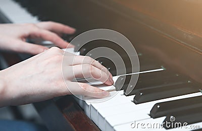 Soft focus photo. Woman is playing piano. Hands on the keyboard. Beautiful music. Creative girl at the musical instrument. Stock Photo