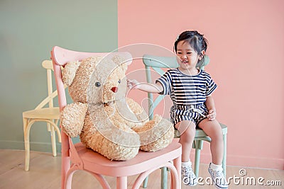 Soft Focus of a Two Years Old Child Sitting with her Teddy Bear. Stock Photo